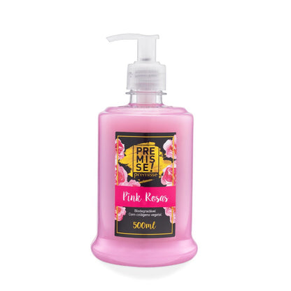Frasco de sabonete líquido Premisse "Pink Rosas" de 500ml, em plástico transparente, com o conteúdo na cor rosa-claro. O frasco possui um bico dosador/válvula pump transparente na parte superior. O rótulo é predominantemente preto, com detalhes dourados e imagens de rosas cor-de-rosa. O rótulo central exibe o nome da marca "PREMISSE!" e o produto "Pink Rosas", com a indicação de que é biodegradável e contém colágeno vegetal.